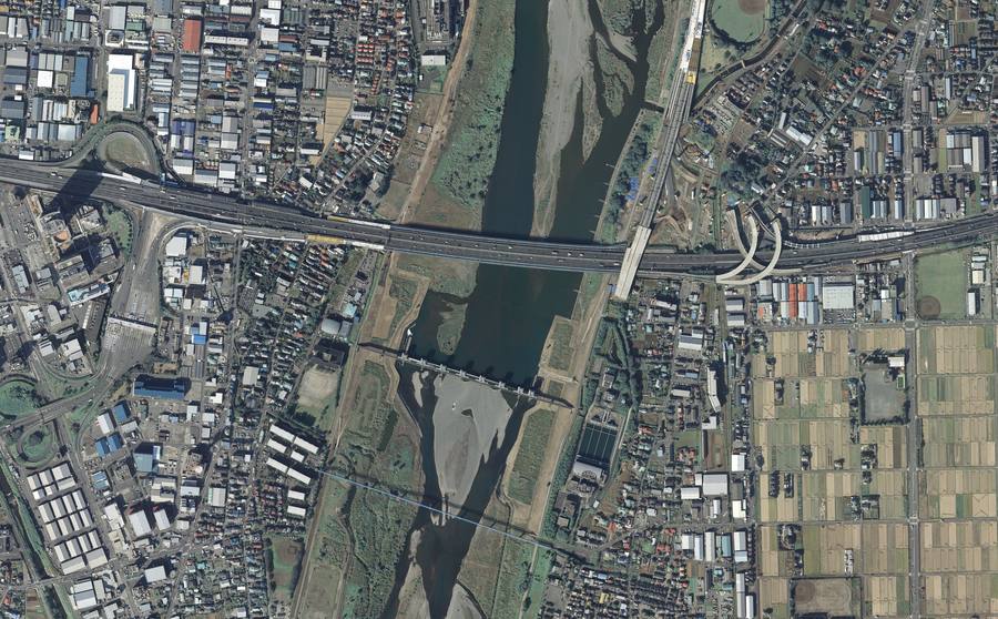 東名の相模川橋東側に建設途中の曲線道路が見える海老名JCT付近