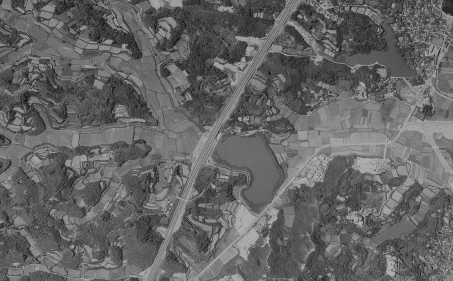 田畑と池の間を斜めに通る1964年の名神高速道路